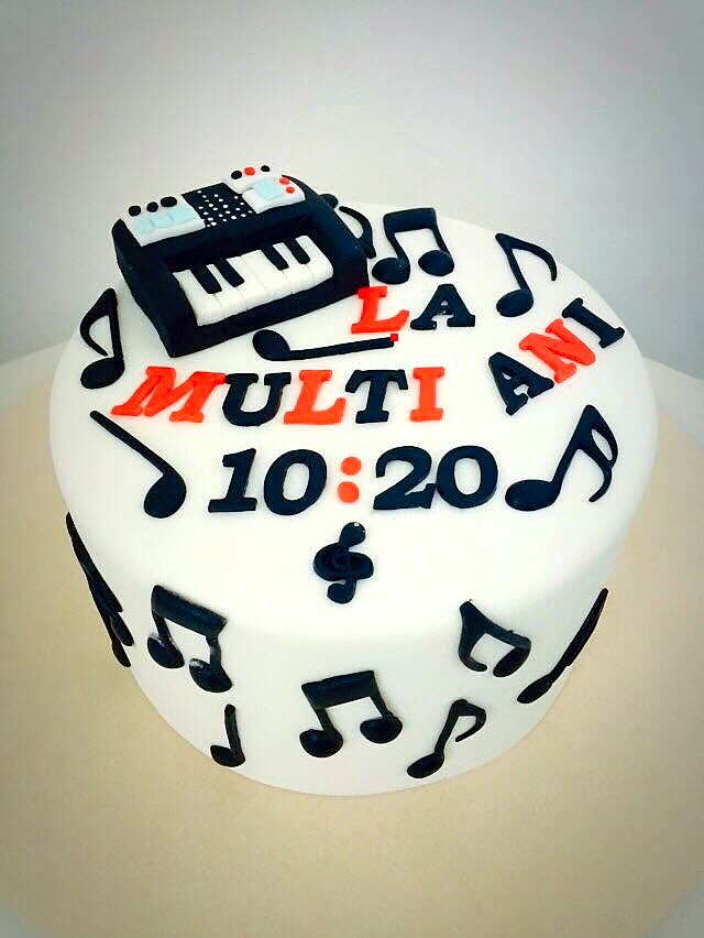 Tort alb cu note muzicale și claviatură din pastă de zahăr