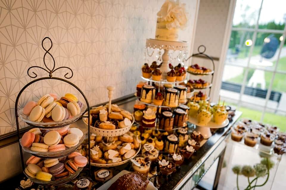 Etajeră cu macarons, tartelete și prăjituri mici la un eveniment