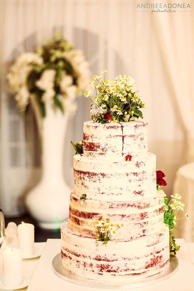 Tort de nuntă cu blat la vedere, decorat cu mușețel și verdeață